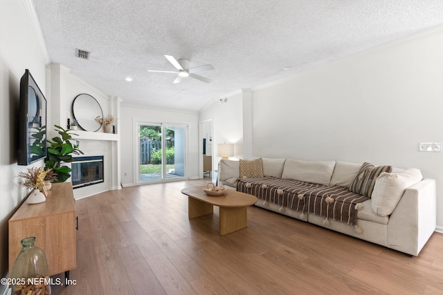1578 Linkside Dr, Atlantic Beach, FL 32233 - living room with ornamental molding, a textured ceiling, a ceiling fan, wood finished floors, and a premium fireplace