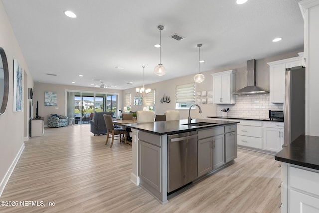 7 Los Lagos Blvd, Palm Coast, FL 32137 - kitchen with stainless steel appliances, wall chimney range hood, dark countertops, recessed lighting, and light wood-style floors