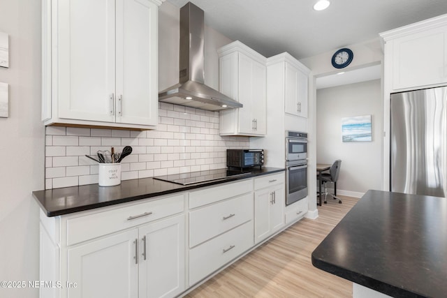 7 Los Lagos Blvd, Palm Coast, FL 32137 - kitchen featuring wall chimney range hood, appliances with stainless steel finishes, dark countertops, tasteful backsplash, and light wood-style flooring