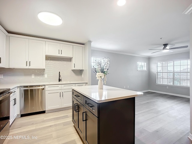 3591 Kernan Blvd S Unit 127, Jacksonville, FL 32224 - kitchen with appliances with stainless steel finishes, a ceiling fan, light countertops, white cabinets, and backsplash