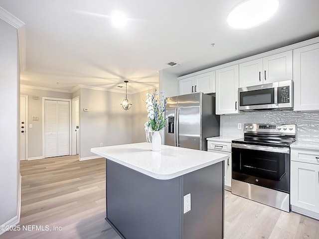 3591 Kernan Blvd S Unit 127, Jacksonville, FL 32224 - kitchen featuring appliances with stainless steel finishes, light wood-type flooring, white cabinets, crown molding, and a center island