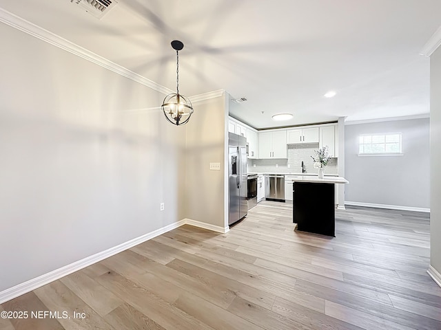 3591 Kernan Blvd S Unit 127, Jacksonville, FL 32224 - kitchen with stainless steel appliances, ornamental molding, light countertops, a chandelier, and light wood-style floors