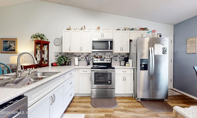 1860 Killarn Cir, Middleburg, FL 32068 - kitchen with stainless steel appliances, lofted ceiling, tasteful backsplash, light countertops, and white cabinets