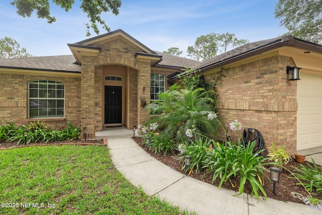 12581 Ashglen Dr N, Jacksonville, FL 32224 - entrance to property with brick siding, a garage, and roof with shingles