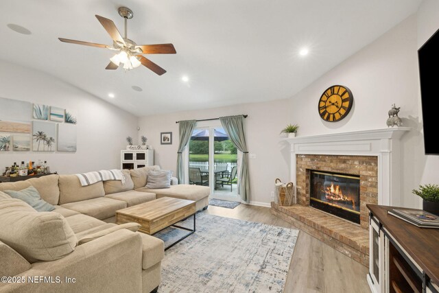 12581 Ashglen Dr N, Jacksonville, FL 32224 - living area with vaulted ceiling, a ceiling fan, a fireplace, light wood finished floors, and recessed lighting