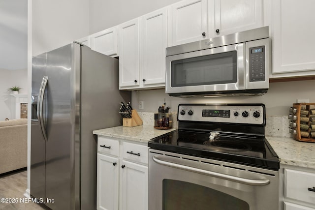 12581 Ashglen Dr N, Jacksonville, FL 32224 - kitchen with appliances with stainless steel finishes, white cabinets, and light stone counters