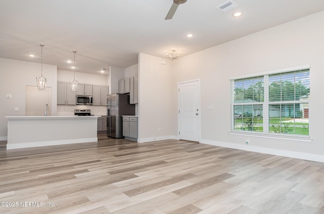5 Squadron Pl, Palm Coast, FL 32164 - kitchen with appliances with stainless steel finishes, gray cabinetry, a chandelier, open floor plan, and a ceiling fan