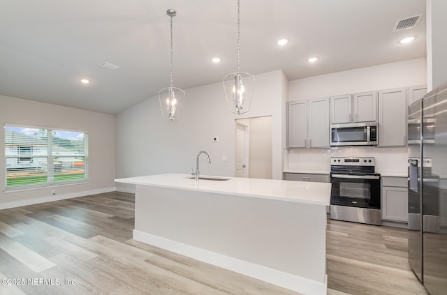 5 Squadron Pl, Palm Coast, FL 32164 - kitchen with appliances with stainless steel finishes, gray cabinets, light wood-style floors, backsplash, and light countertops