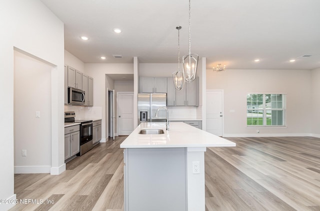 5 Squadron Pl, Palm Coast, FL 32164 - kitchen featuring stainless steel appliances, gray cabinetry, light wood-style flooring, tasteful backsplash, and recessed lighting