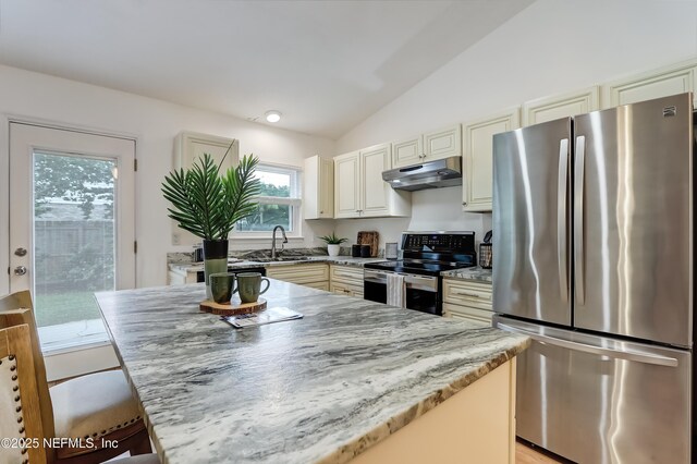 1803 Oakbreeze Ct, Jacksonville Beach, FL 32250 - kitchen featuring freestanding refrigerator, range with electric stovetop, under cabinet range hood, lofted ceiling, and cream cabinets