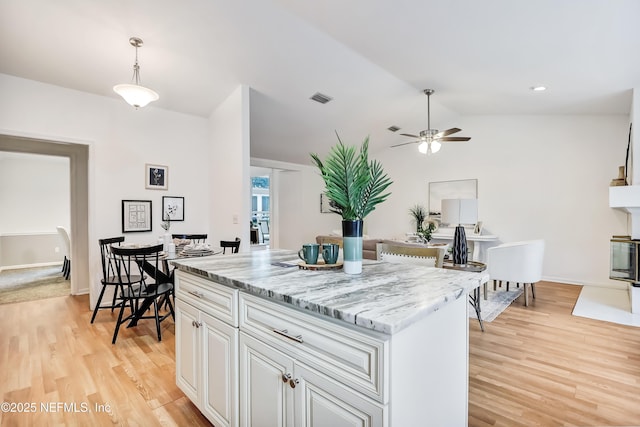 1803 Oakbreeze Ct, Jacksonville Beach, FL 32250 - kitchen with a ceiling fan, light wood-style flooring, white cabinetry, a center island, and vaulted ceiling