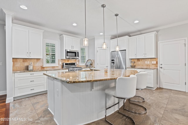 201 History Pl, Saint Augustine, FL 32095 - kitchen with appliances with stainless steel finishes, crown molding, white cabinetry, backsplash, and a breakfast bar area