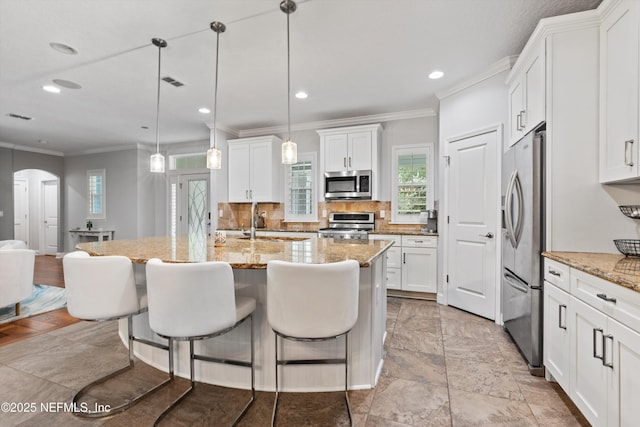 201 History Pl, Saint Augustine, FL 32095 - kitchen featuring stainless steel appliances, crown molding, white cabinets, a breakfast bar, and recessed lighting
