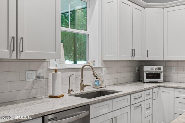 791 Paradise Ln, Atlantic Beach, FL 32233 - kitchen with stainless steel dishwasher, white cabinets, and plenty of natural light