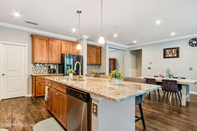 207 Hertford Bridge Way, Saint Johns, FL 32259 - kitchen with stainless steel dishwasher, refrigerator with ice dispenser, brown cabinets, dark wood-type flooring, and a kitchen island with sink
