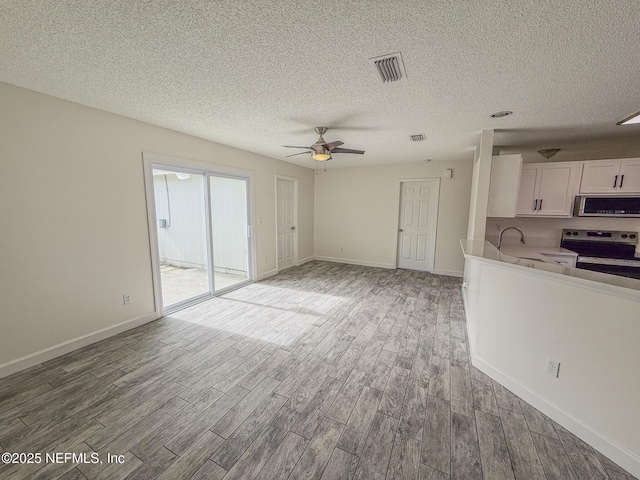1736 Ashwood Cir, Middleburg, FL 32068 - unfurnished living room with wood finished floors, a ceiling fan, and a textured ceiling