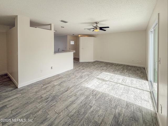 1736 Ashwood Cir, Middleburg, FL 32068 - unfurnished living room with wood finished floors, ceiling fan, and a textured ceiling