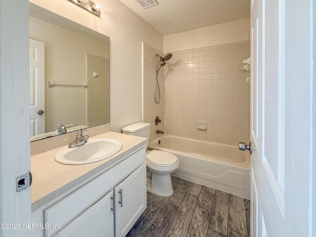 1736 Ashwood Cir, Middleburg, FL 32068 - full bathroom with wood finished floors, vanity, a textured ceiling, and  shower combination