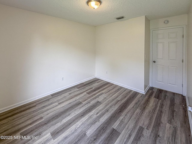 1736 Ashwood Cir, Middleburg, FL 32068 - empty room featuring a textured ceiling and dark wood-type flooring