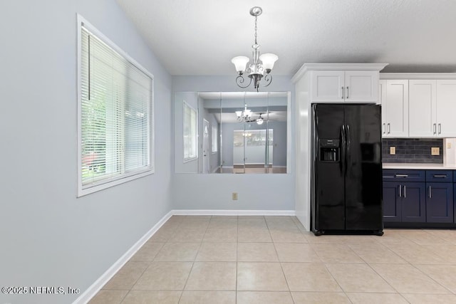6202 Columbine Dr, Jacksonville, FL 32211 - kitchen with black fridge with ice dispenser, a chandelier, healthy amount of natural light, and white cabinets