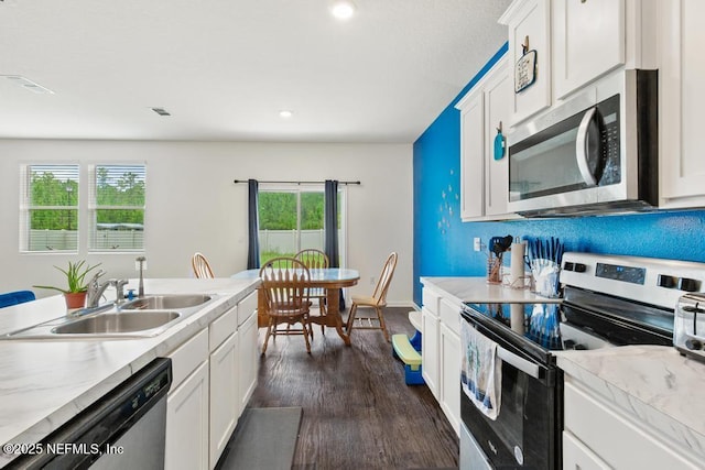 65490 Crested Heron Ct, Yulee, FL 32097 - kitchen featuring appliances with stainless steel finishes, light countertops, white cabinetry, dark wood-style floors, and recessed lighting