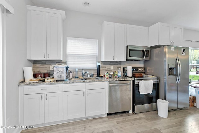 850 Bruen St, Saint Augustine, FL 32084 - kitchen with appliances with stainless steel finishes, white cabinets, light stone countertops, decorative backsplash, and recessed lighting