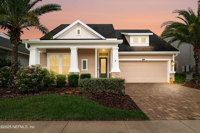 91 Paradise Valley Dr, Ponte Vedra, FL 32081 - view of front of property featuring decorative driveway, an attached garage, covered porch, stone siding, and a shingled roof