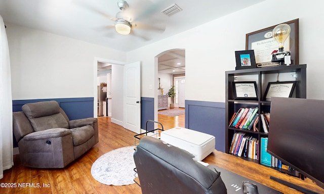 90 SE Forest St, Keystone Heights, FL 32656 - sitting room featuring arched walkways, ceiling fan, wood finished floors, and a wainscoted wall