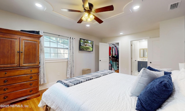 90 SE Forest St, Keystone Heights, FL 32656 - bedroom featuring light wood finished floors, a walk in closet, a closet, ensuite bathroom, and a ceiling fan