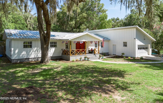90 SE Forest St, Keystone Heights, FL 32656 - manufactured / mobile home featuring a porch, a front yard, a metal roof, a garage, and board and batten siding