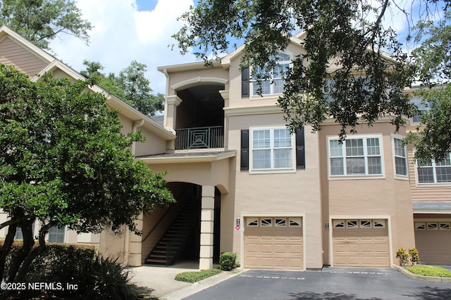 13810 Sutton Park Dr N Unit 528, Jacksonville, FL 32224 - townhome / multi-family property featuring an attached garage, stucco siding, driveway, and a balcony