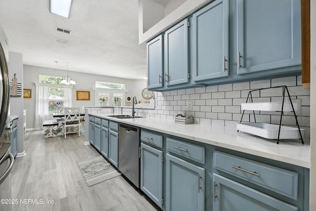 3172 Twilight Ct, Middleburg, FL 32068 - kitchen featuring stainless steel dishwasher, light wood-type flooring, backsplash, blue cabinets, and decorative light fixtures