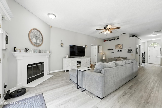 3172 Twilight Ct, Middleburg, FL 32068 - living room featuring a ceiling fan, light wood-type flooring, and a glass covered fireplace