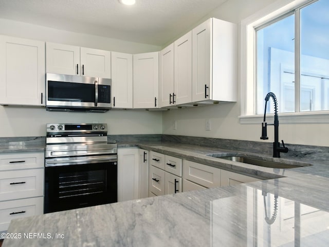 6615 Camelot Ct, Keystone Heights, FL 32656 - kitchen featuring stainless steel appliances, stone counters, and white cabinetry