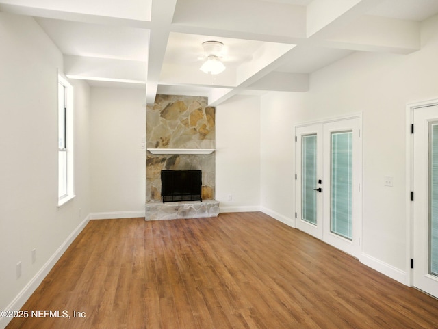 6615 Camelot Ct, Keystone Heights, FL 32656 - unfurnished living room with wood finished floors, beamed ceiling, french doors, ceiling fan, and a fireplace