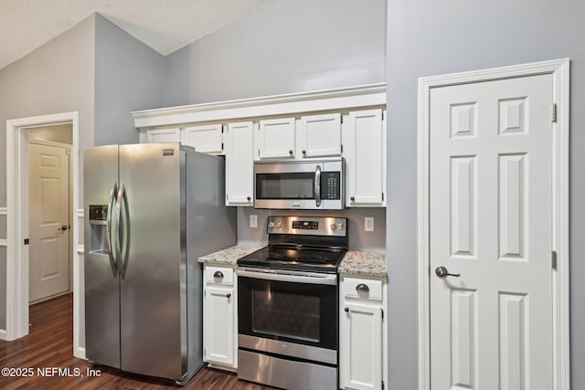 12551 Hunters Branch Way, Jacksonville, FL 32224 - kitchen with stainless steel appliances, dark wood-type flooring, white cabinetry, light stone countertops, and a textured ceiling