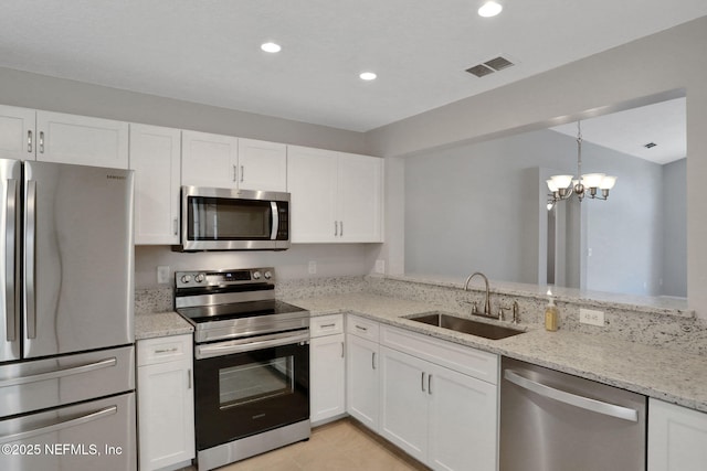 732 Putters Green Way, Saint Johns, FL 32259 - kitchen with stainless steel appliances, white cabinetry, light stone countertops, a chandelier, and light tile patterned floors