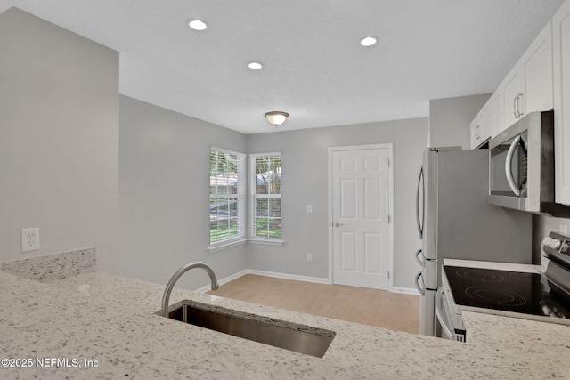 732 Putters Green Way, Saint Johns, FL 32259 - kitchen with white electric range, stainless steel microwave, light stone counters, light wood finished floors, and white cabinetry