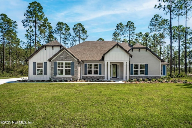 36295 Pitch Ln, Hilliard, FL 32046 - view of front of house featuring board and batten siding, stone siding, a front yard, and roof with shingles