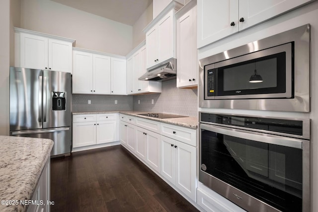 36295 Pitch Ln, Hilliard, FL 32046 - kitchen with appliances with stainless steel finishes, under cabinet range hood, decorative backsplash, white cabinets, and dark wood-style flooring