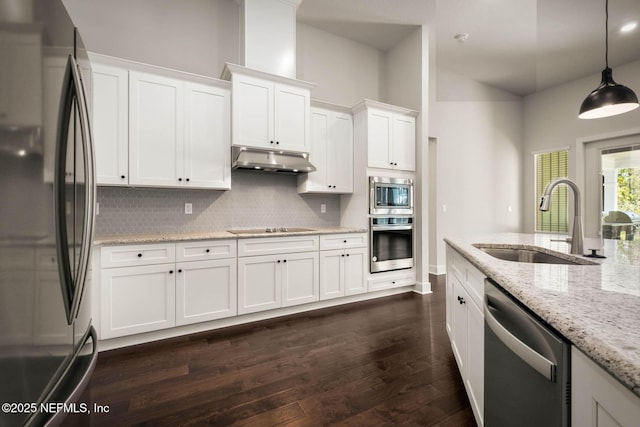 36295 Pitch Ln, Hilliard, FL 32046 - kitchen with stainless steel appliances, under cabinet range hood, tasteful backsplash, white cabinetry, and a high ceiling