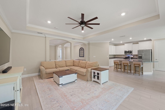 37 Tobago Ln, Saint Augustine, FL 32092 - living room featuring a tray ceiling, ceiling fan, arched walkways, crown molding, and recessed lighting