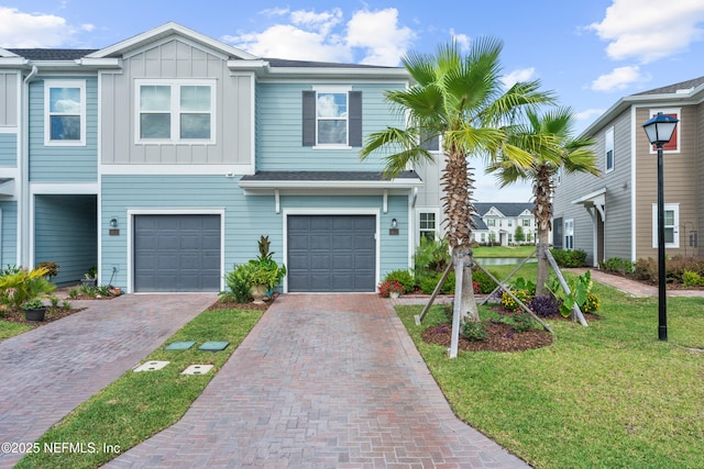 67 Carmella Ct, Saint Augustine, FL 32092 - townhome / multi-family property with board and batten siding, driveway, a front yard, and an attached garage