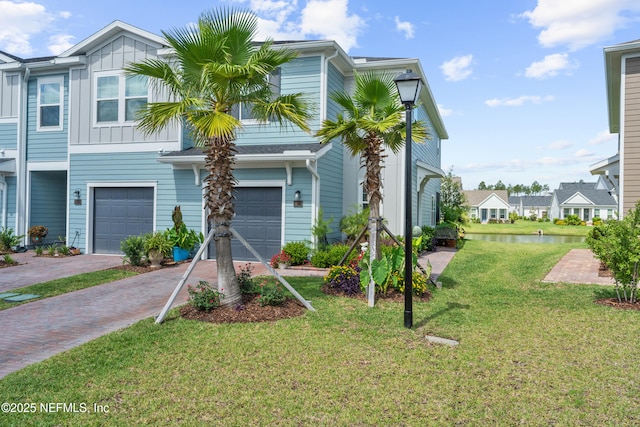 67 Carmella Ct, Saint Augustine, FL 32092 - townhome / multi-family property featuring an attached garage, a water view, decorative driveway, a front yard, and board and batten siding