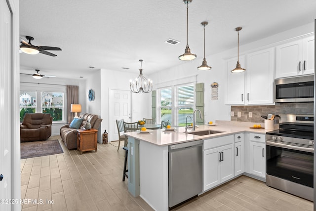 67 Carmella Ct, Saint Augustine, FL 32092 - kitchen with appliances with stainless steel finishes, light wood-type flooring, open floor plan, light countertops, and a textured ceiling