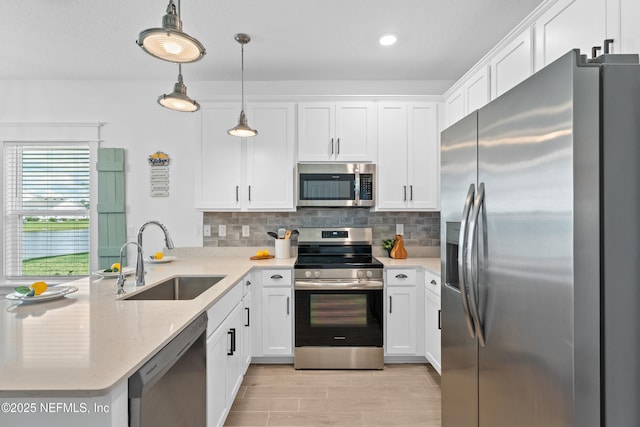 67 Carmella Ct, Saint Augustine, FL 32092 - kitchen with stainless steel appliances, a peninsula, backsplash, white cabinets, and recessed lighting