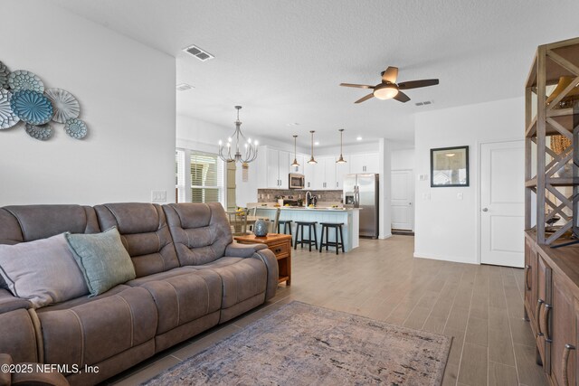 67 Carmella Ct, Saint Augustine, FL 32092 - living room with a ceiling fan, a chandelier, and wood finished floors