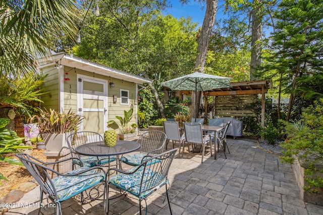 111 S 4th St, Fernandina Beach, FL 32034 - view of patio featuring outdoor dining area, grilling area, and a shed