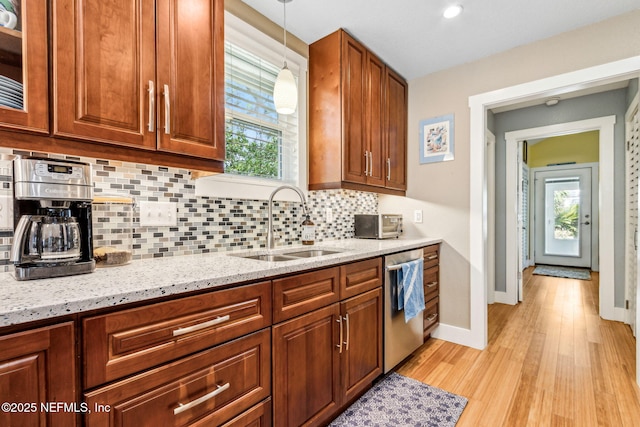 111 S 4th St, Fernandina Beach, FL 32034 - kitchen with stainless steel dishwasher, light wood-style flooring, healthy amount of natural light, light stone countertops, and recessed lighting