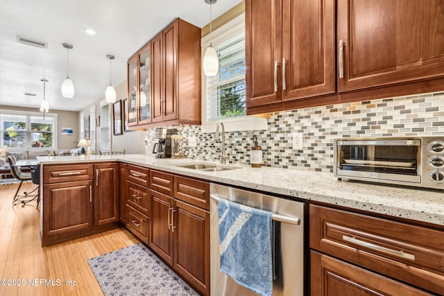 111 S 4th St, Fernandina Beach, FL 32034 - kitchen with dishwasher, light wood-type flooring, a peninsula, and light stone countertops